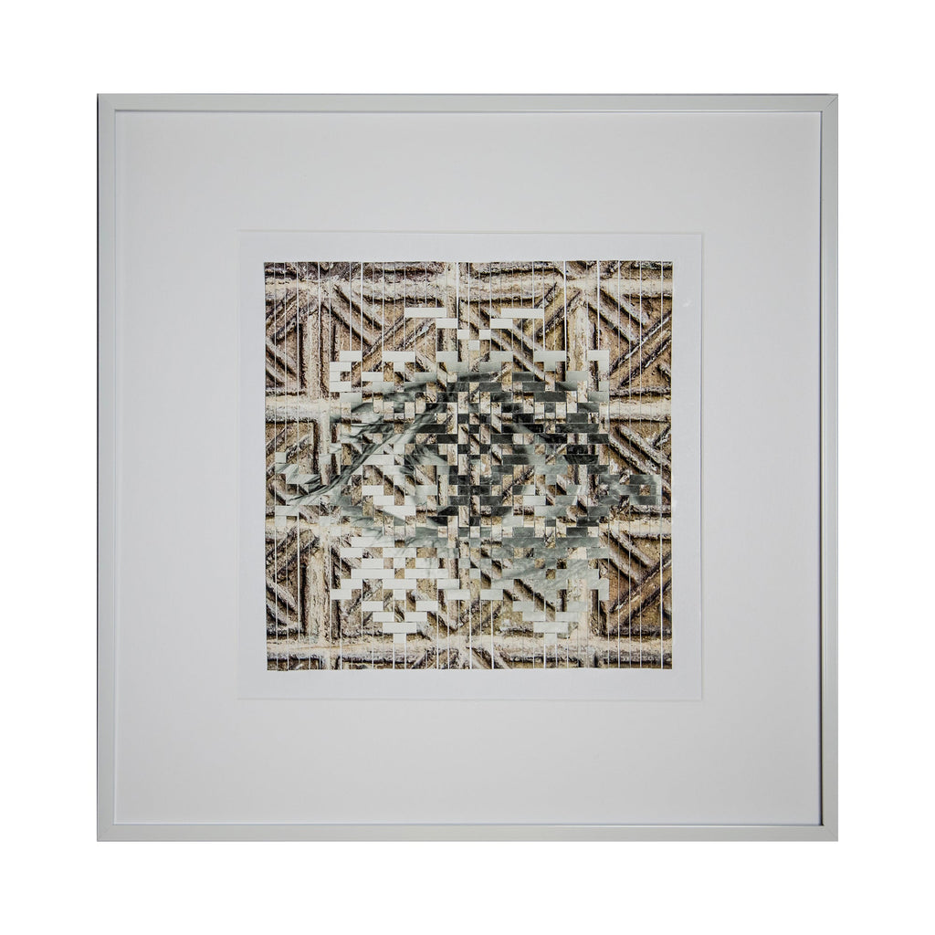 The artwork 'Geometric Clash' by Kiana Honarmand features intricate hand-cut and woven giclee prints arranged in a complex geometric pattern. Angular shapes and lines create a mesmerizing central motif in muted browns and grays, framed against a white mat in a modern silver frame. The layered design combines traditional geometric patterns with contemporary artistic techniques.