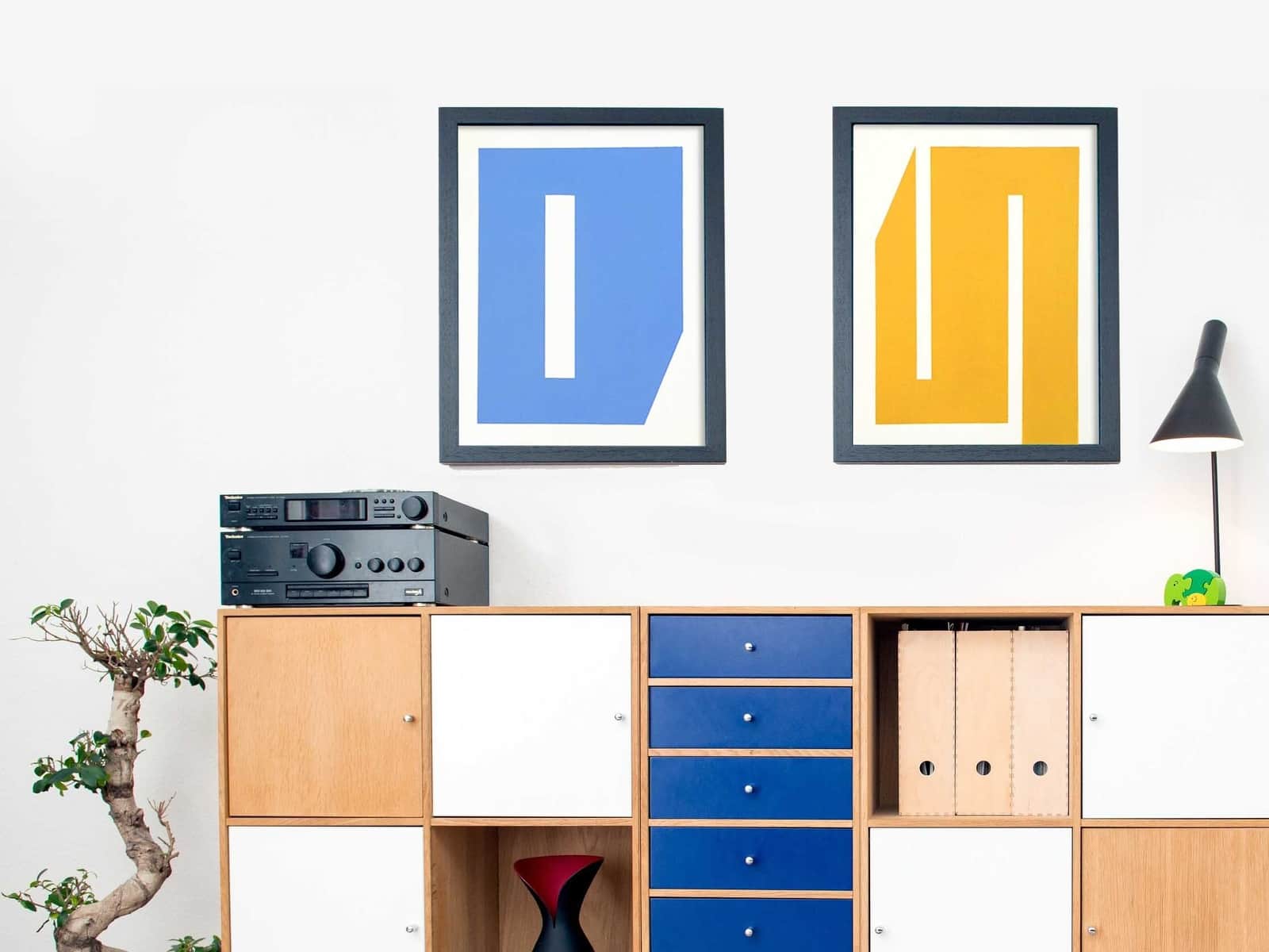 Gallery wall set up for a kid's room with blue and yellow geometric paintings