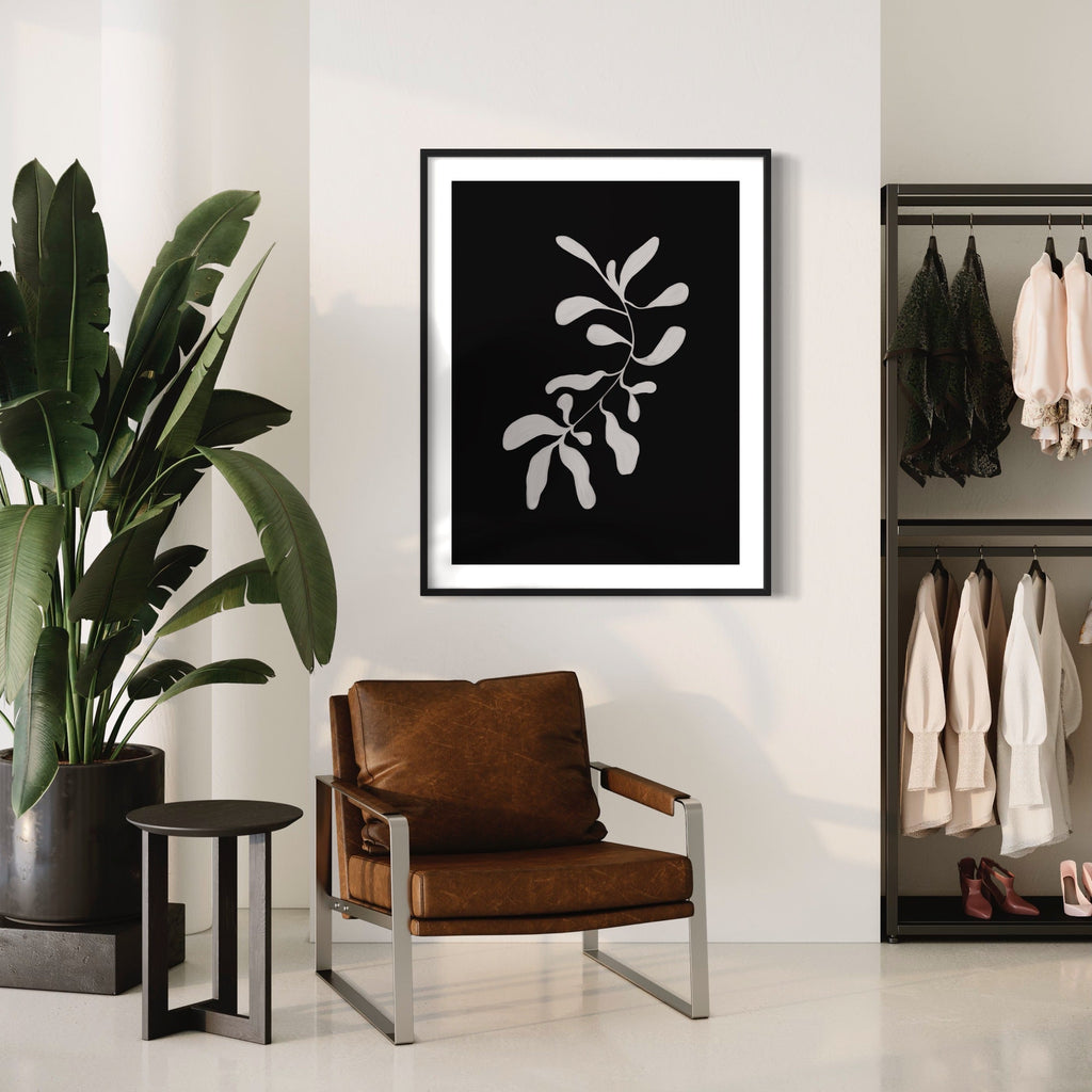 The artwork 'Floral Black And White' by Alina Glotova features a minimalist botanical print showcasing a delicate branch with leaves rendered in white against a deep black background. The monochromatic composition creates a striking silhouette effect, capturing the elegant simplicity of natural forms in a contemporary 40x30 inch print.
