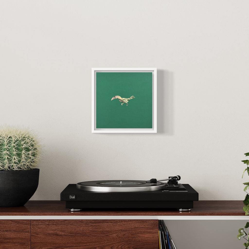 The artwork 'Profit Margins, Toucan' by Jacki Davis features a minimalist collage of a toucan crafted from US currency against a deep emerald green background, presented in a white frame. The bird is depicted in flight, rendered in intricate currency details on wood panel with acrylic accents, sized 8x8 inches.