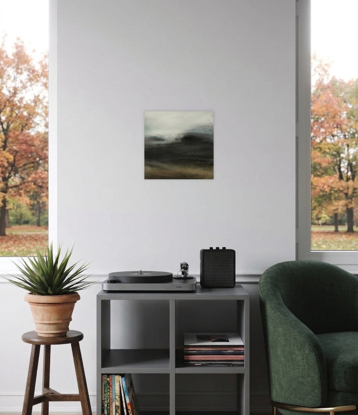 In the Mist II by Xanthippe Tsalimi presents a subtle abstract landscape with muted grays and earthy hues evoking a calm, foggy ambiance, showcased in a minimalist room with modern furniture and autumnal views beyond large windows.
