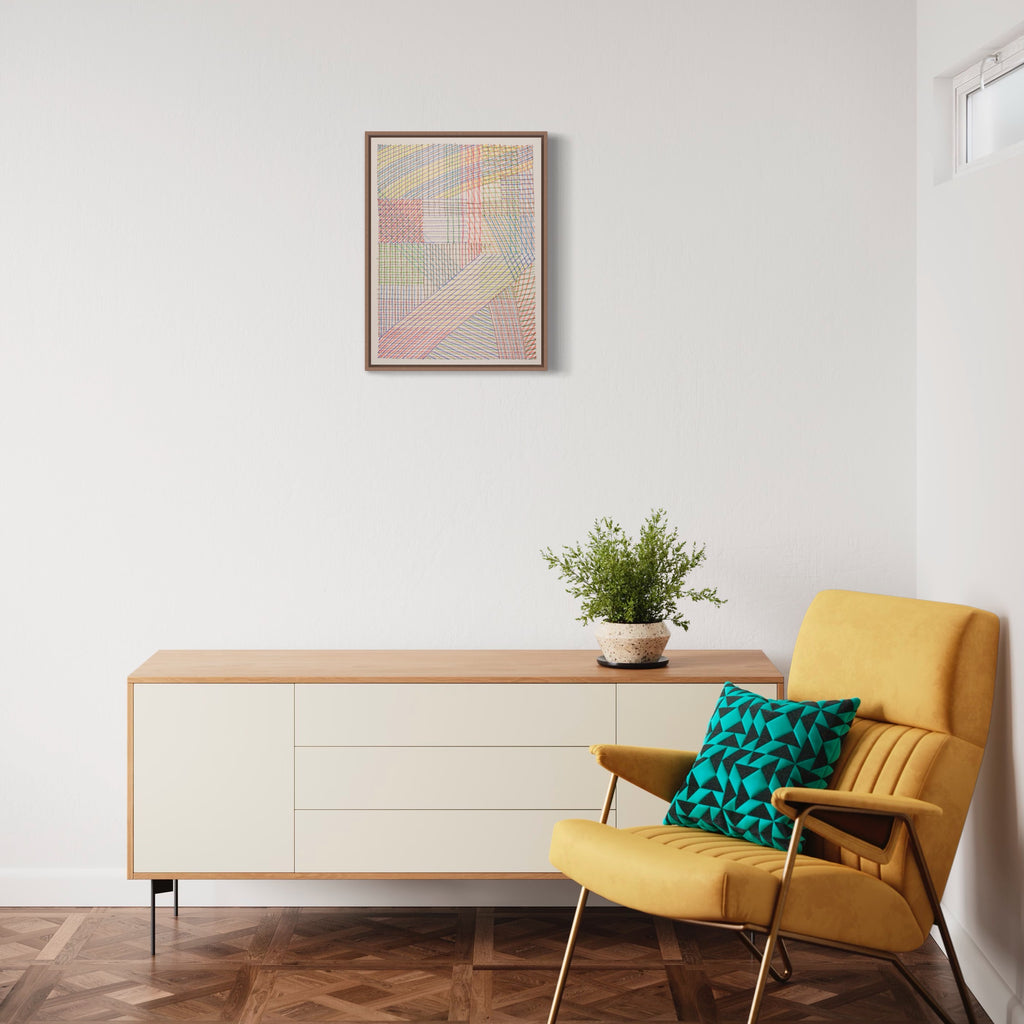 The artwork 'Layered Meditation' by Lynnette Therese Sauer features delicate intersecting geometric patterns in soft pastel hues of pink, blue, and gray. Created with colored pencil on paper, the abstract composition showcases intricate layered lines forming a meditative grid-like structure. The 24x18 inch piece is elegantly framed and displayed above a modern interior setting.