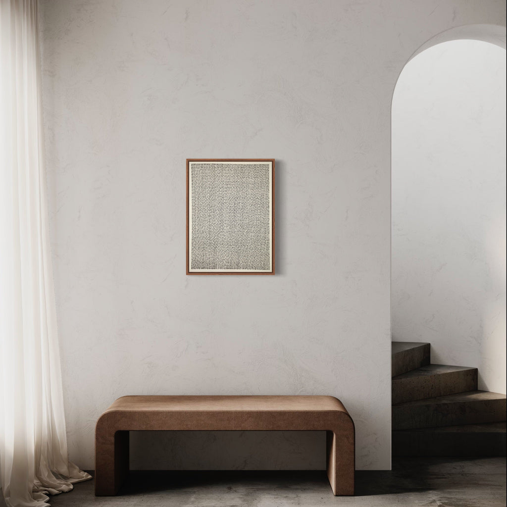 The artwork 'Meditation XX (open heart)' by Lynnette Therese Sauer features minimalist ink patterns on paper in a wooden frame, displayed above a curved brown bench in a serene white room with arched doorway and flowing curtains. The monochromatic artwork showcases delicate textures and geometric patterns, complementing the modern minimalist interior setting.