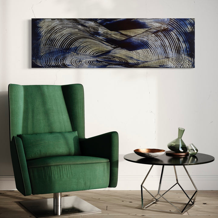 The artwork 'Eminence Front' by John Cox features sweeping, dynamic brushstrokes creating wave-like patterns in metallic silver, deep navy blue, and charcoal gray. Abstract curved lines flow horizontally across the canvas, suggesting movement and rhythm. The acrylic painting's textural elements and undulating forms create a modern, contemporary aesthetic by John Cox.