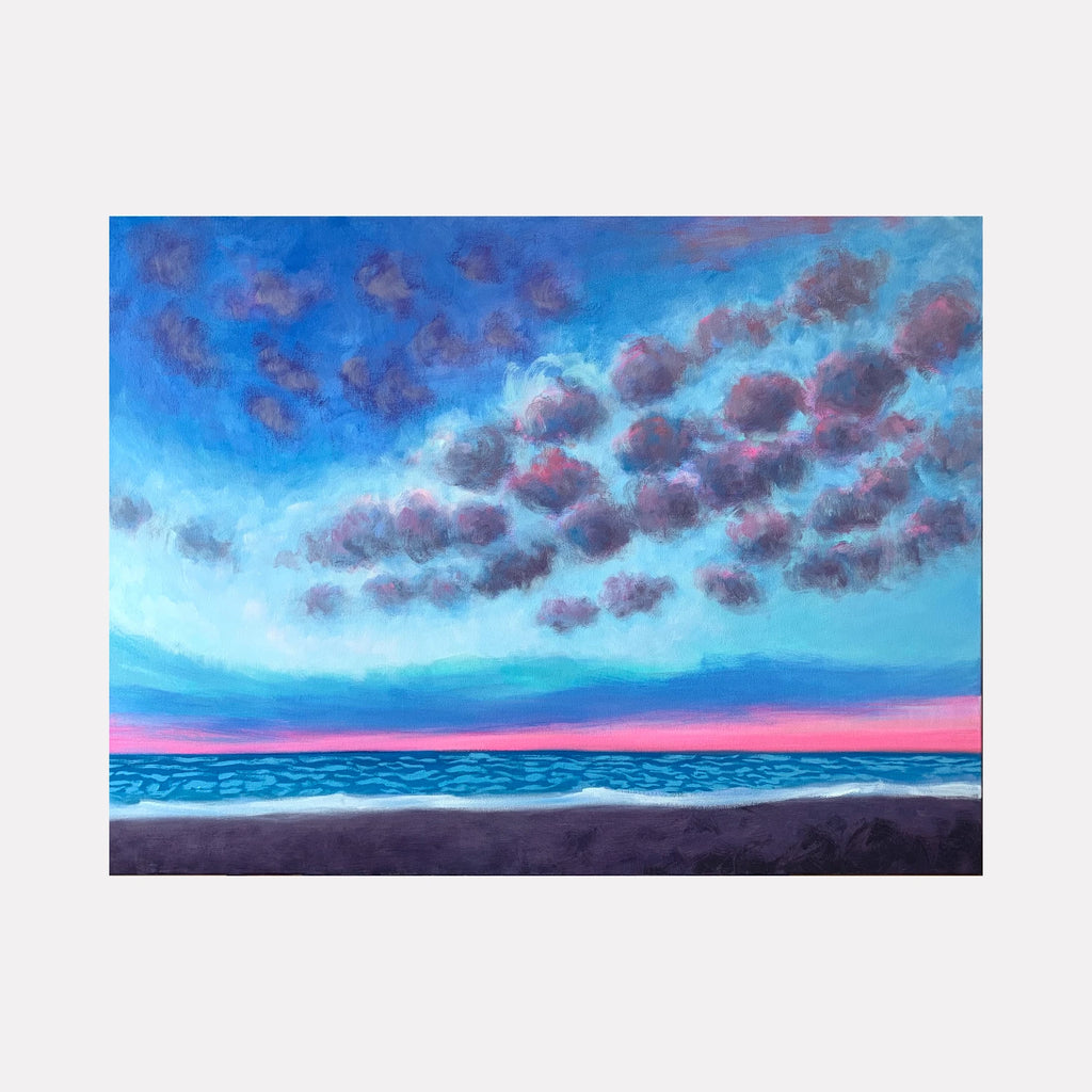 Beach by Melanie Kozol is a Curina art piece depicting an expansive shoreline under a dynamic sky filled with softly textured clouds. The horizon glows with pink and blue tones, blending tranquil sea waves with a moody yet serene atmosphere.