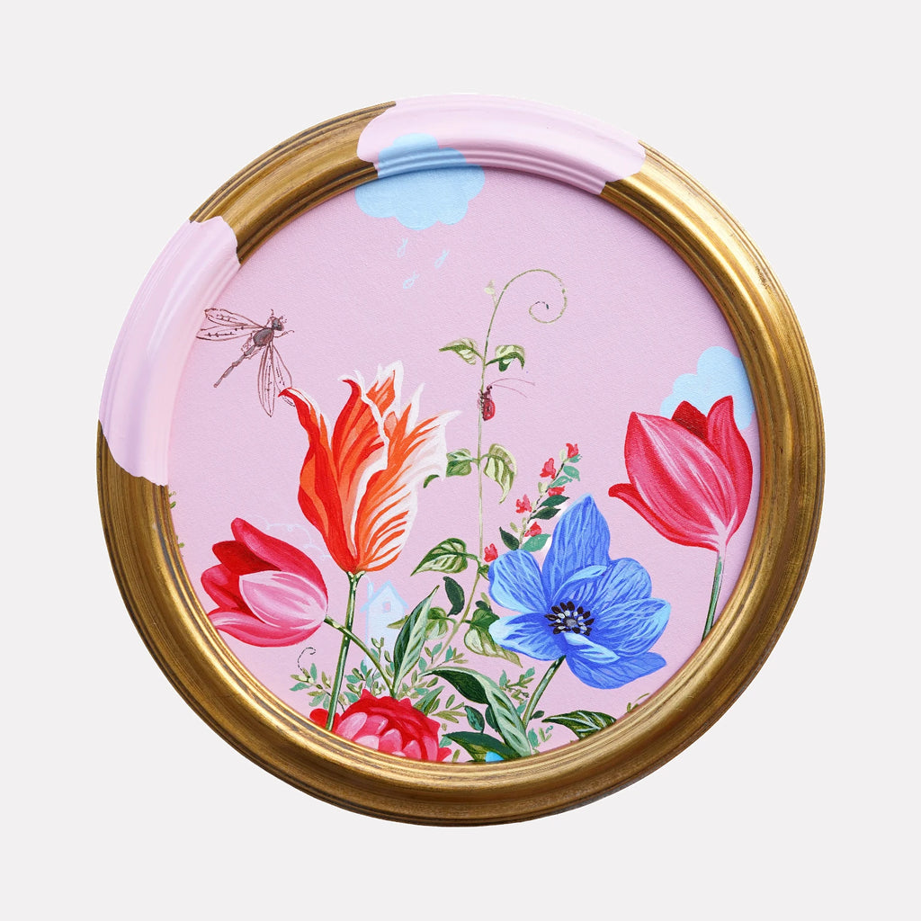 Where Precision Meets the Audacity of Blooming Anyway by Carlos Gamez de Francisco is a Curina art piece featuring vibrant red, pink, and blue flowers against a pastel pink background with whimsical clouds, set within a partially painted gold circular frame.