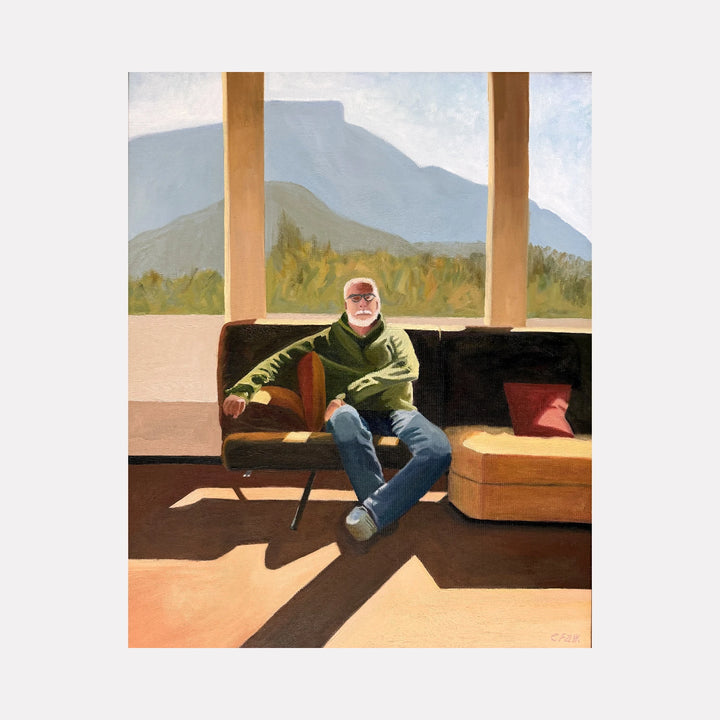 That's No Gentleman by Connie Falk is a Curina art piece depicting a relaxed man seated on a sofa bathed in warm sunlight, framed by tall pillars and a serene mountain landscape in the background, capturing a tranquil and contemplative moment with natural light and shadow.