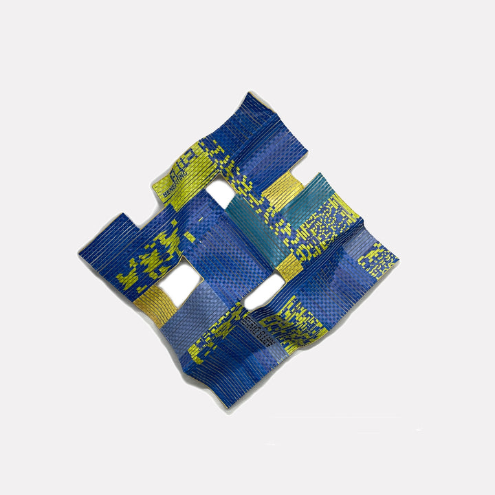 Hudson # 3 by Shelley Heffler is a Curina art piece featuring a textured, folded abstract form in vibrant blues and yellows with a grid-like pattern, conveying a dynamic, modern expression through its layered, sculptural design.