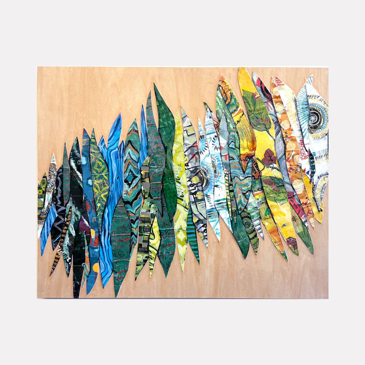 Murmurs by Christina Massey is a Curina art piece featuring a series of elongated, leaf-like shapes arranged in a flowing horizontal pattern with vibrant, textured colors ranging from deep blues and greens to warm yellows and oranges on a natural wood background.