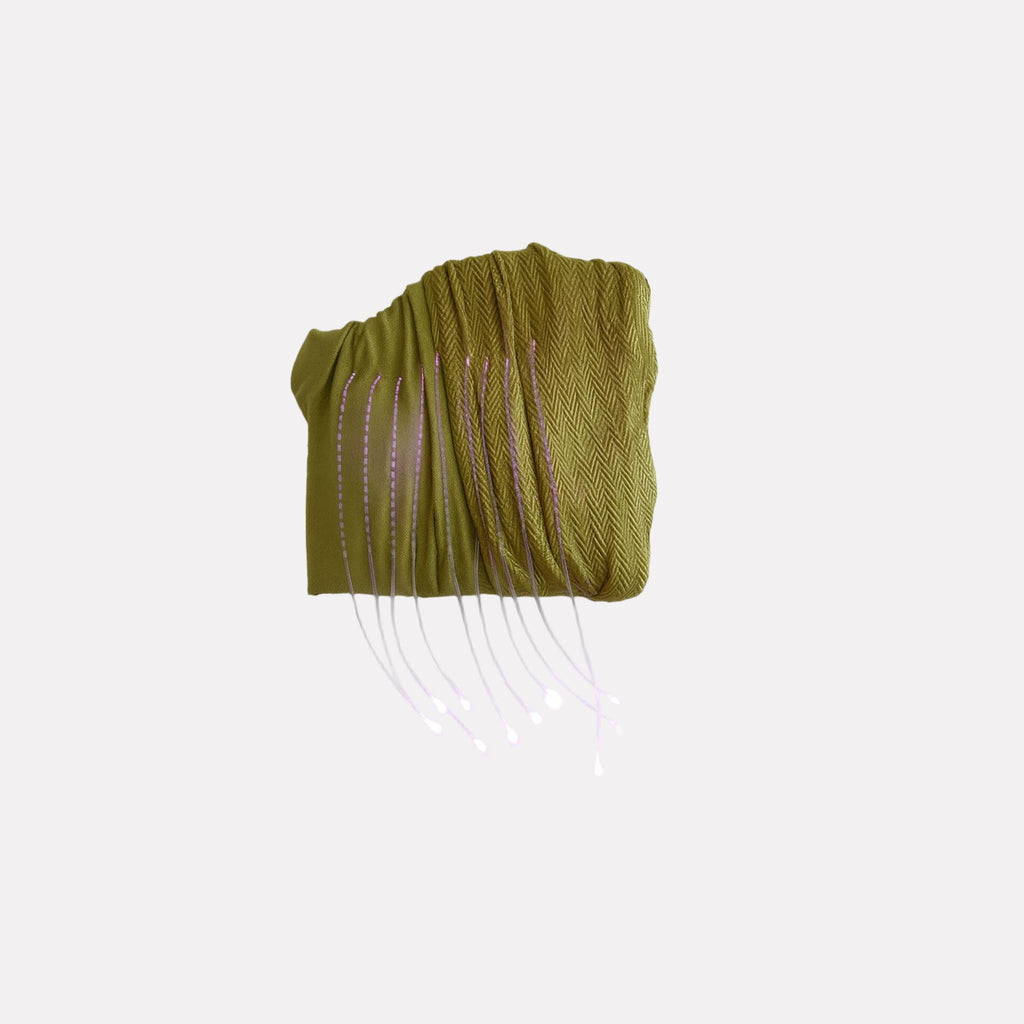Ancient Futures (bug #4) by Craftwork features an abstract green textured form with a woven pattern and delicate, flowing white lines extending downward, blending tactile fabric-like surfaces with ethereal, organic motion in a contemporary art style.