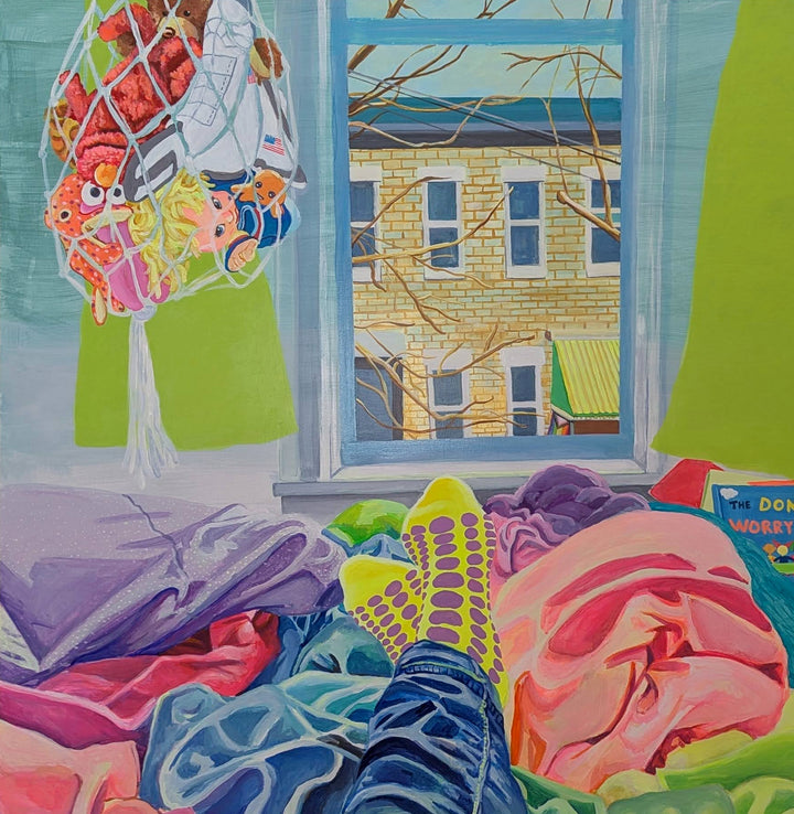 The artwork "She Keeps It All Together" by Mary Younkin depicts a cozy indoor scene with vibrant acrylic colors on a wood panel, featuring a view through a window of a brick building and leafless trees. Inside, colorful textiles, clothing, and socks with purple dots are scattered, creating a warm, lived-in atmosphere. Mary Younkin
