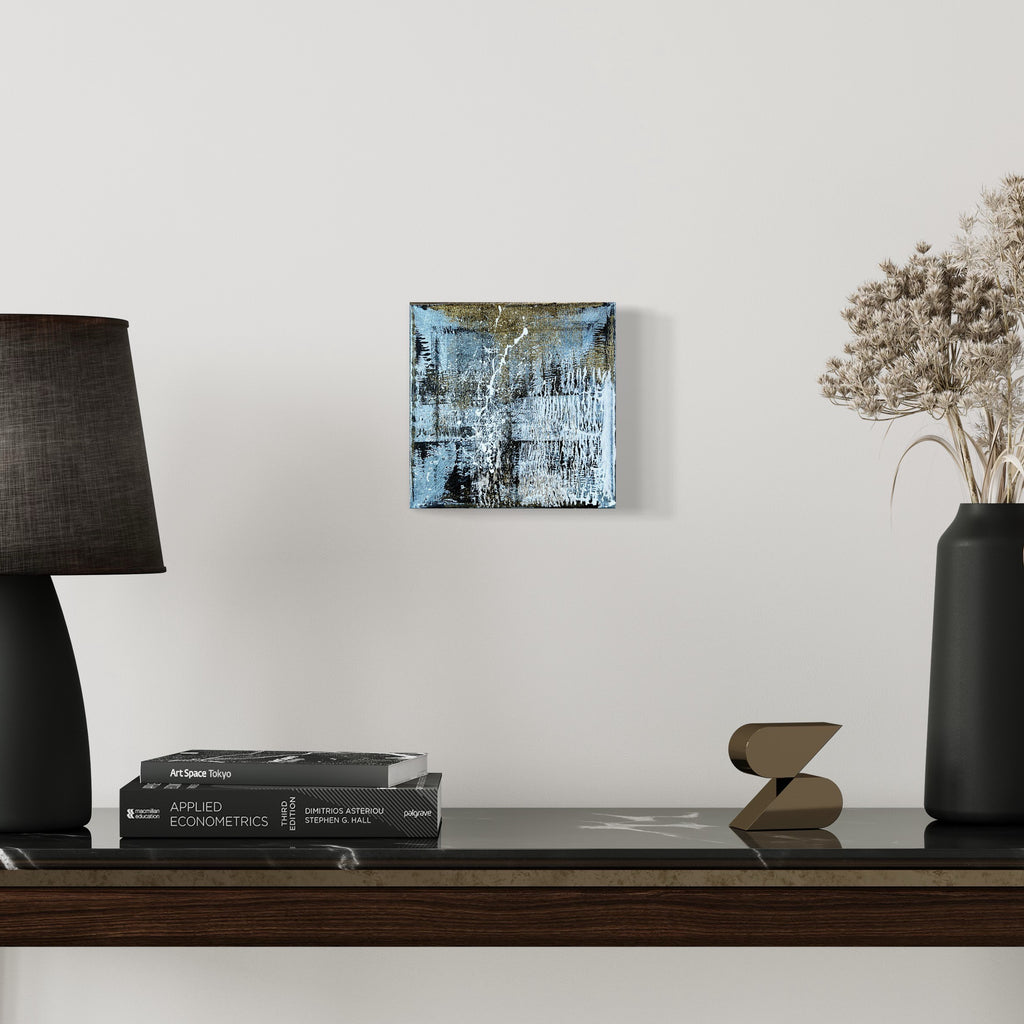 The artwork 'Rapture 4' by Bill Burns features a striking abstract composition in metallic acrylic on canvas, displaying layers of icy blue and silvery tones with textured brushstrokes creating a weathered, industrial effect. Dark undertones emerge through distressed surfaces, giving depth and complexity to this 8x8 inch contemporary piece.