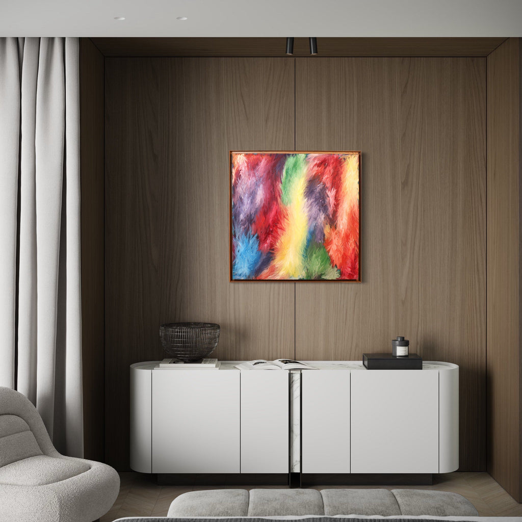 The artwork 'Rising 5' by Bill Burns features vibrant abstract swirls of red, yellow, blue, and green oil paint on canvas, creating a dynamic and energetic composition. The bold brushstrokes flow seamlessly together, suggesting movement and emotional intensity, displayed against a modern interior with wood paneling. 36x36 inches oil painting by Bill Burns.