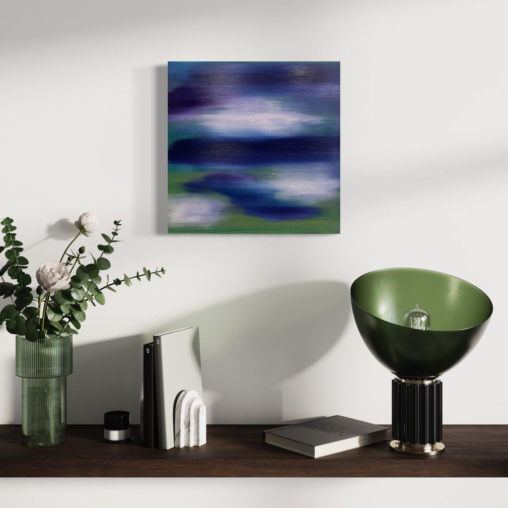 The artwork 'Serenity 2' by Bill Burns features ethereal abstract layers of deep navy blue and violet blending into misty white, creating a dreamlike atmospheric effect. Subtle green undertones emerge beneath the dominant cool tones, painted with fluid brushstrokes in oil on wood panel. The composition evokes a tranquil coastal landscape at twilight.
