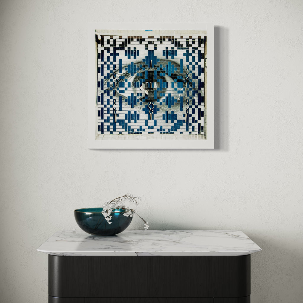The artwork 'The Blue Door' by Kiana Honarmand features an intricate geometric pattern in black and white, with a striking blue central motif. Hand-cut and woven giclee prints create a mesmerizing pixelated effect, combining traditional Persian design elements with contemporary digital aesthetics in an 18x18 inch square format. By Kiana Honarmand.
