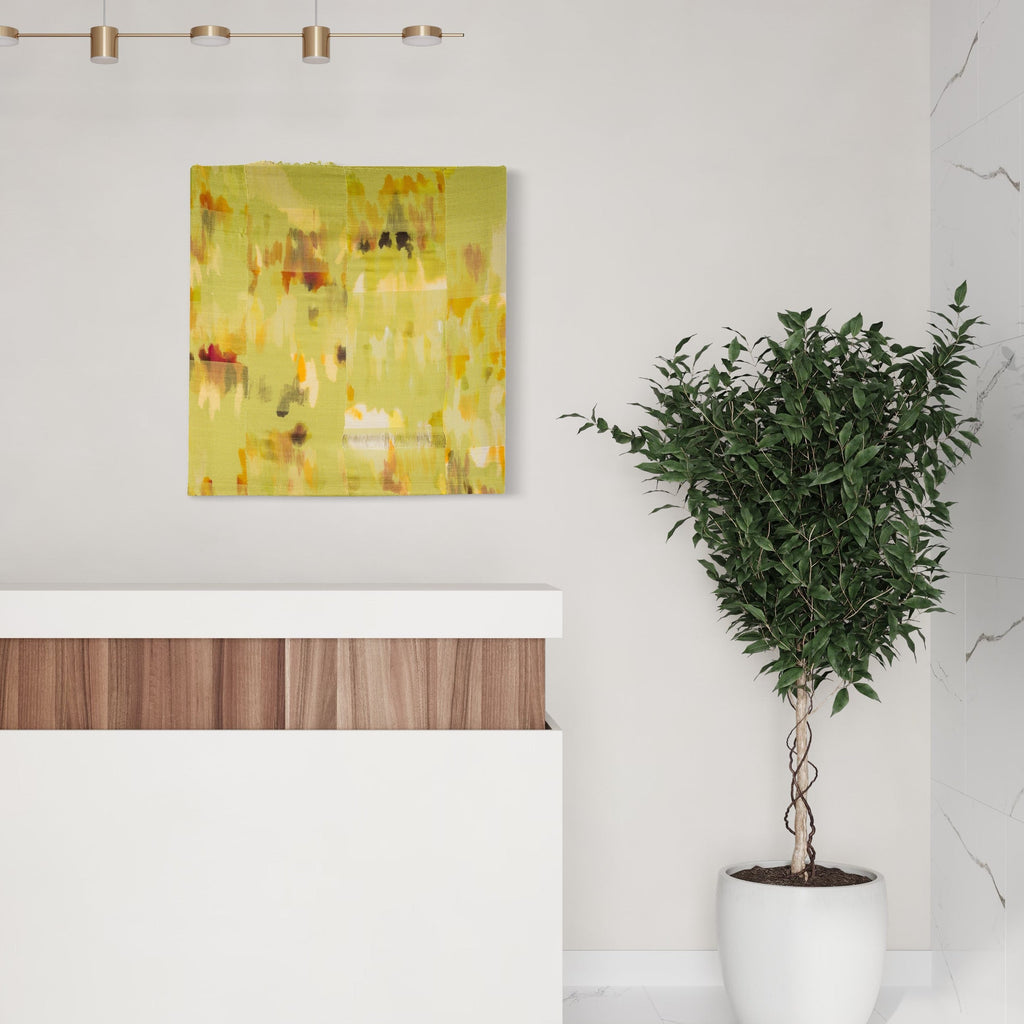 The artwork 'Untitled 13' by Victoria Manganiello features abstract brushstrokes in vibrant yellows, chartreuse, and burnt orange hues blending seamlessly across natural and synthetic fibers. The 38x36 inch textile piece displays a impressionistic pattern with subtle color variations and ethereal texture creating a luminous, dreamlike quality.