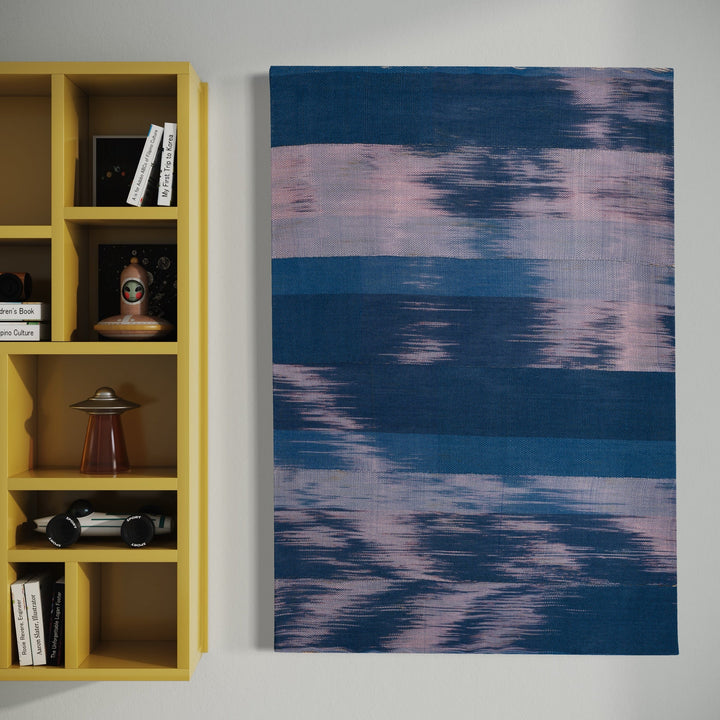 The artwork 'Untitled 156' by Victoria Manganiello features horizontal brushstrokes in deep navy blue and soft pink creating a watercolor-like effect. The abstract textile piece showcases ethereal blending patterns resembling rippling water or clouded skies, handcrafted using natural and synthetic fibers with dyes on a 32x46 inch canvas.