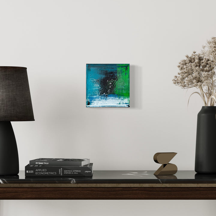 The artwork 'Voyage 3' by Bill Burns features a striking abstract composition with vibrant turquoise blue and emerald green hues merging dramatically against a dark accent. The 8x8 inch acrylic painting on canvas showcases expressive brushstrokes and textural elements, creating a dynamic interplay of colors reminiscent of ocean waves meeting forest landscapes.