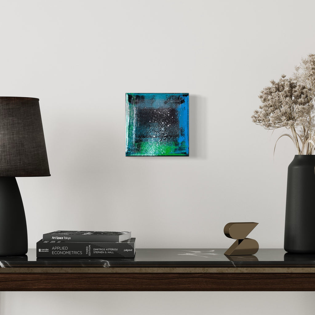 The artwork 'Voyage 4' by Bill Burns features a vibrant abstract composition on an 8x8 canvas, blending deep turquoise and emerald hues with a speckled effect reminiscent of starlit night sky. The acrylic paint creates a glossy, textured surface with subtle gradients transitioning from dark to light, displayed against a minimalist white wall setting.