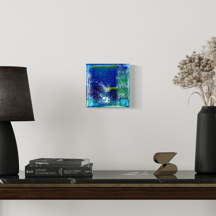 The artwork 'Voyage 7' by Bill Burns features a vibrant abstract composition on an 8x8 canvas. Deep oceanic blues blend with ethereal turquoise and emerald green tones, creating a dynamic interplay of colors. Textured brushstrokes and layered acrylic paint suggest underwater movement and depth, with scattered white highlights adding luminosity to the piece by Bill Burns.