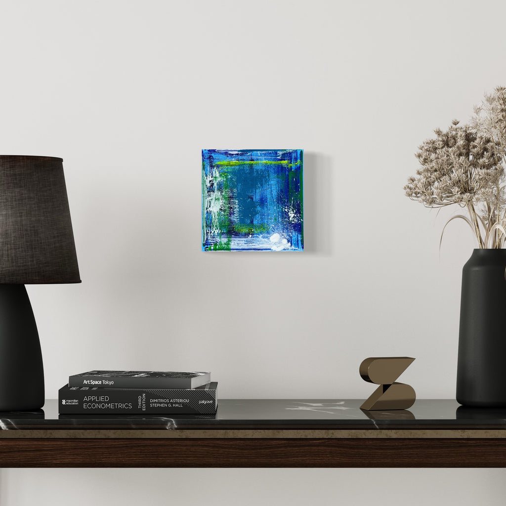 The artwork 'Voyage 8' by Bill Burns features vibrant layers of turquoise and cobalt blue acrylic paint on canvas, creating an abstract seascape effect with dynamic brushstrokes. White accents and emerald green undertones add depth, while textured edges suggest movement and flowing water within the 8x8 inch square composition
