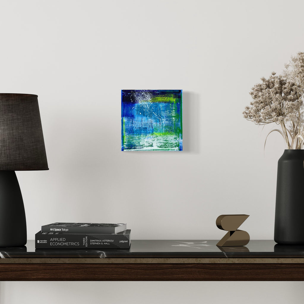 The artwork 'Voyage 9' by Bill Burns features vibrant layers of turquoise, cobalt blue, and lime green acrylic paint on canvas. Abstract brushstrokes create a watery, ethereal effect with textural elements suggesting movement and depth. The 8x8 inch composition evokes an underwater seascape or aerial view of tropical waters.
