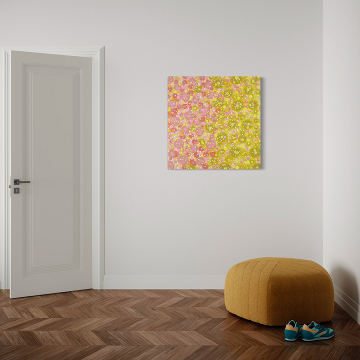 The artwork 'Delightfully Delectable' by Eric Jiaju Lee features a vibrant abstract composition on canvas with blended yellow and pink hues creating a dappled, impressionistic effect. The 36x36 inch acrylic painting displays a luminous, dotted pattern reminiscent of spring blossoms or scattered light, mounted on a clean white wall.