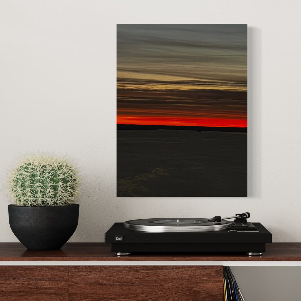 The artwork Fire & Ice 1 by Starr Tucker-Ortega features a dramatic landscape with a bold horizontal division between a deep black foreground and a vibrant fiery red stripe above it, topped with layered gray and muted yellow clouds. The textured gradation and contrasting colors evoke the intense emotional style of Mark Rothko’s color field paintings while maintaining a minimalist abstract aesthetic.