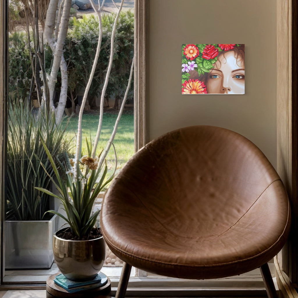 The artwork 'Amapola III' features a partial view of a face surrounded by vibrant floral elements, including red roses, coral-orange gerbera daisies, and delicate purple blooms against lush green foliage. The acrylic painting on wood showcases detailed brushwork and a striking botanical composition by Carlos Gamez de Francisco.