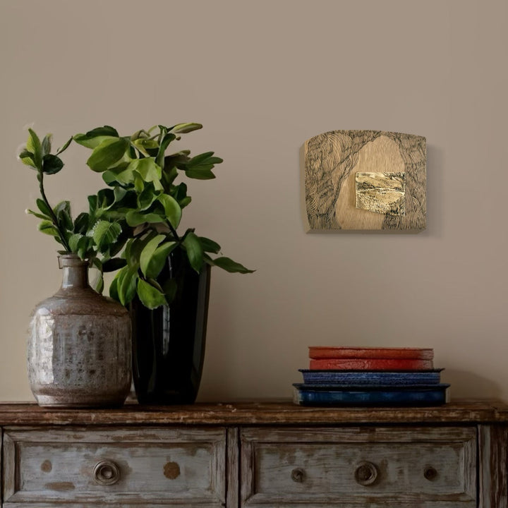 A photo of the artwork Burnt Offering - Rembrandt Landscape, by Zoe Cohen, hanging on a wall.