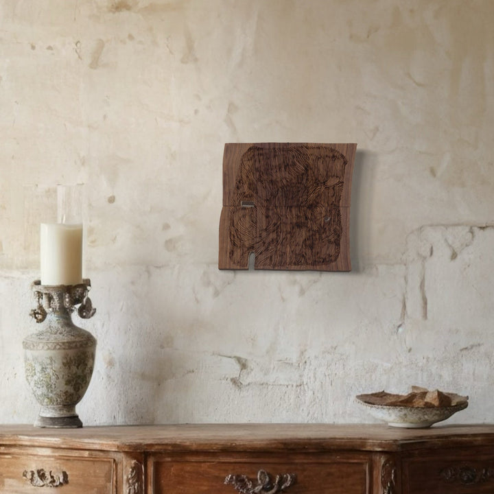 A photo of the artwork Burnt Offering 3, by Zoe Cohen, hanging on a wall.