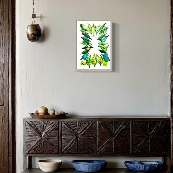 The artwork 'Coronet' by Monica Carrier features a vibrant burst of green and blue watercolor-like shapes radiating from a central white space, creating a dynamic abstract pattern reminiscent of tropical leaves. Rendered in archival ink on paper, the 14x10 inch piece displays crisp edges and translucent overlapping forms that suggest organic movement and natural growth. By Monica Carrier.