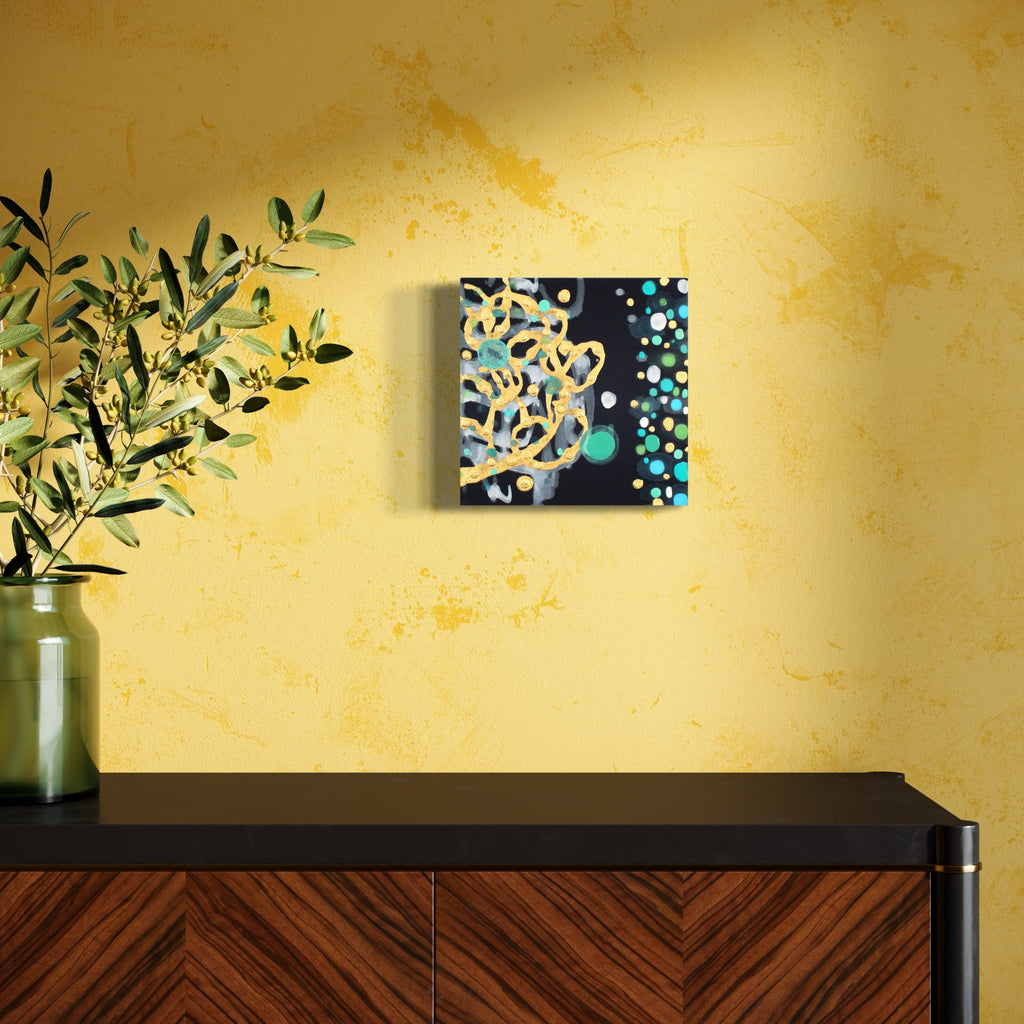 The artwork 'Froth Forth' by Eric Jiaju Lee features abstract swirling patterns in white and gold against a deep navy background, complemented by turquoise dots forming a border. The 12x12 inch acrylic on silk painting creates a dynamic movement reminiscent of underwater bubbles or cosmic formations, displaying a fluid interplay of light and dark elements.