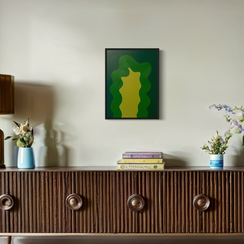 The artwork 'GREEN' by Shadia Sabagh features an abstract organic form in varying shades of emerald and lime green, creating a fluid, layered silhouette against a darker forest green background. The acrylic on canvas painting showcases smooth color transitions and bold minimalist design, measuring 24x18 inches.