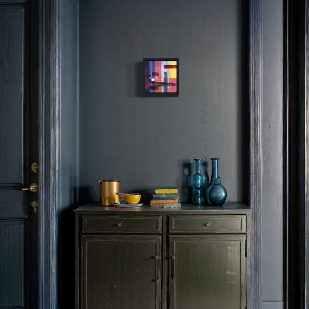 The artwork 'Galactic Shapes' by Arthur Norcome features vibrant geometric abstract watercolor composition in an 8x8 inch frame, displaying bold pink, yellow, and blue rectangular forms against a dark background. Mounted on a grey wall above a vintage cabinet with blue glass vases and gold accents, creating a modern minimalist aesthetic.