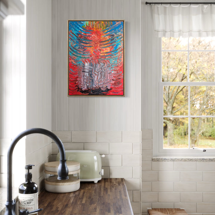 Gutted by Grief by Hillary Hany showcases a vivid abstract design with intense reds, blues, and grays, featuring layered, dynamic strokes that convey emotional depth. Displayed in a bright kitchen space above a wooden countertop near a window, it adds a bold, expressive accent to the neutral-toned room.