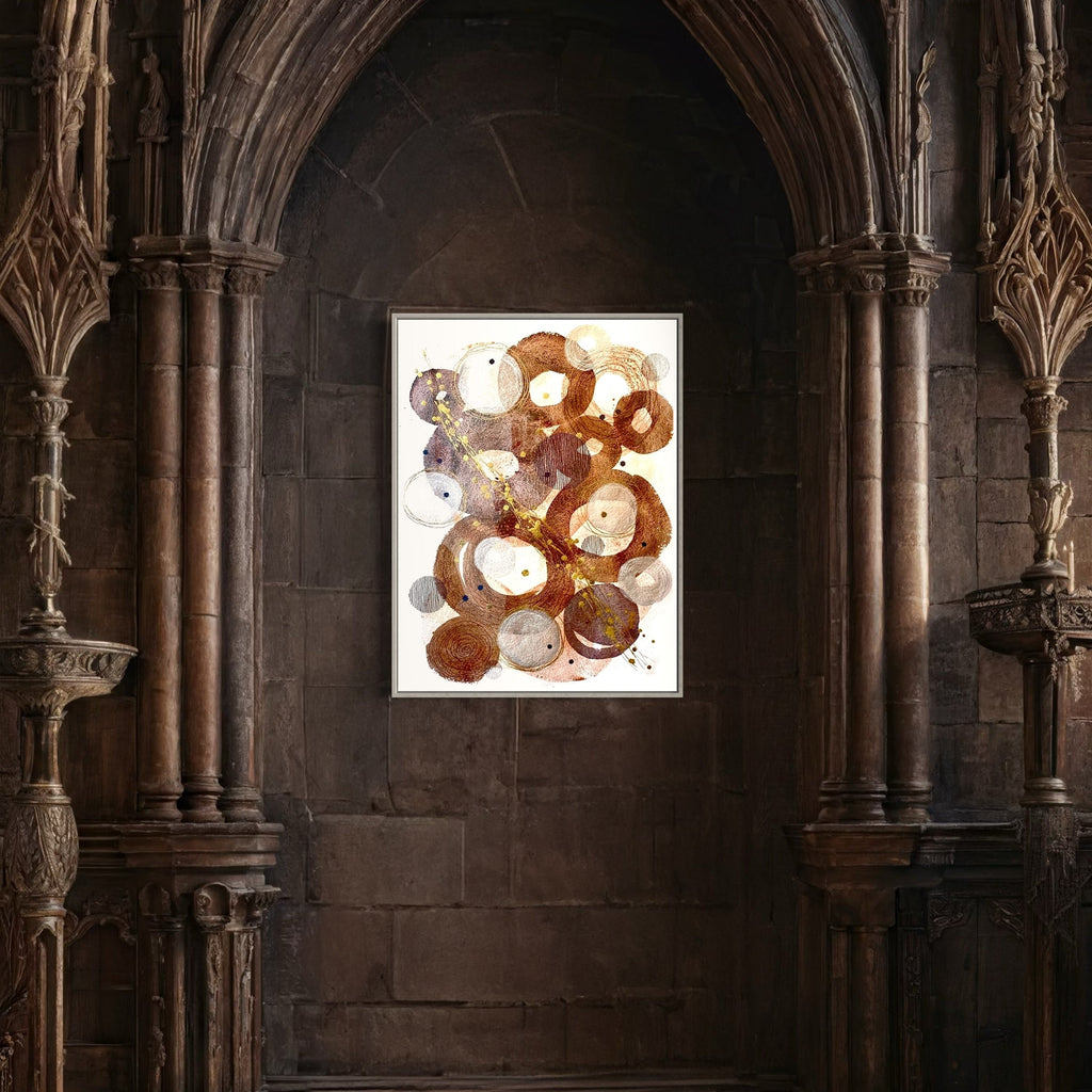 The artwork 'Inner Strength' by Jocelyn Benford features abstract circular formations in rich earth tones, predominantly brown and white, with subtle purple accents. The watercolor technique creates organic, overlapping rings with fluid textures and splatter effects. The composition appears to float on white paper, enclosed in a modern frame against a Gothic architectural backdrop.