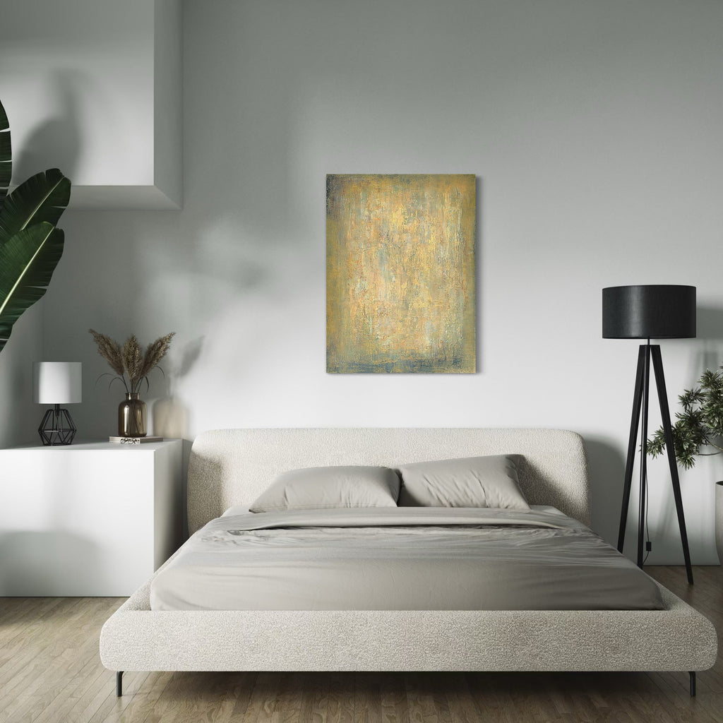 The artwork 'Let Love Open the Door' by Nicole Hitchcock showcases a textural abstract painting in muted gold and sage green tones. The acrylic piece, measuring 48x36 inches, features weathered, distressed surfaces creating a vintage aesthetic. Displayed in a modern bedroom setting above a minimalist bed, the artwork complements contemporary decor with its subtle palette and ethereal composition.