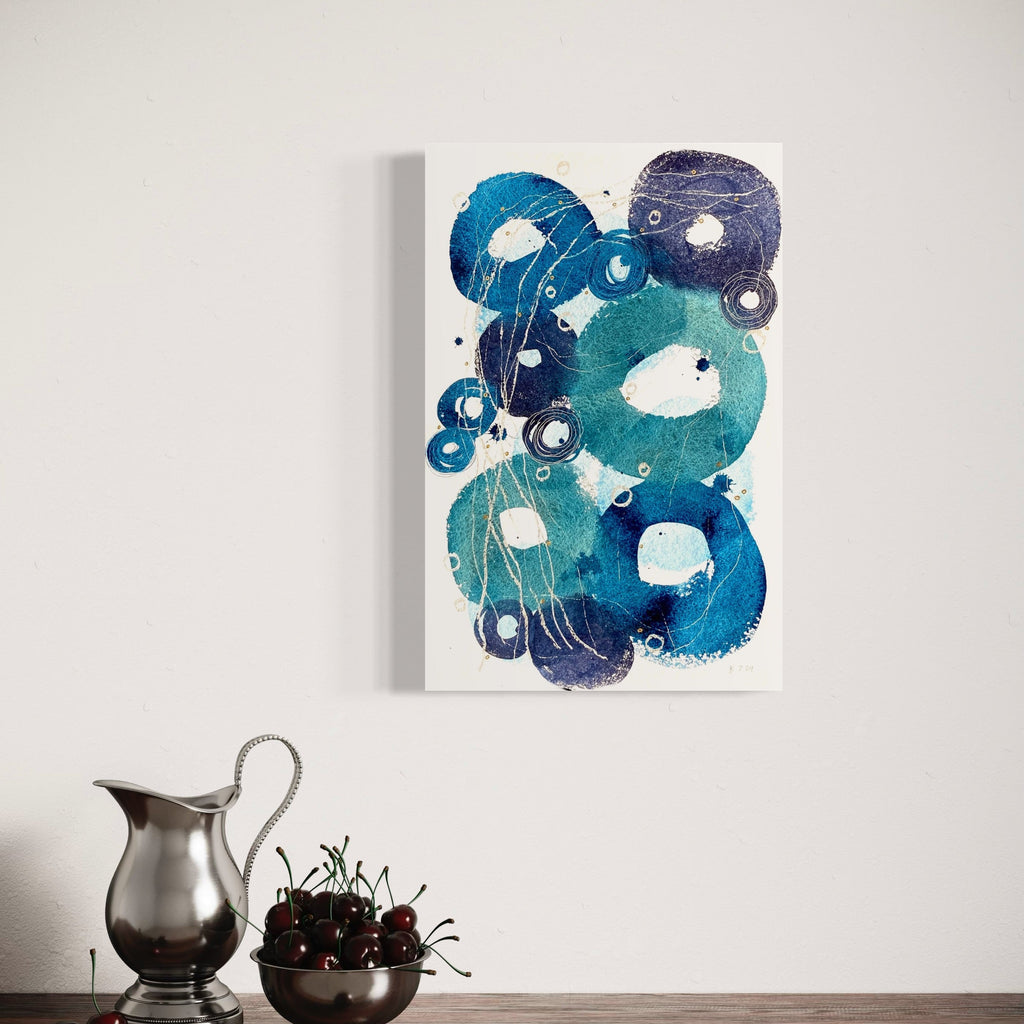 The artwork 'Little Ripples II' by Jocelyn Benford features abstract circular forms in fluid shades of turquoise, navy, and teal watercolor. White negative spaces create ethereal bubbles and organic shapes, while subtle mixed media elements add depth and texture. The composition suggests underwater movement and floating elements across the 23x15 inch paper surface.