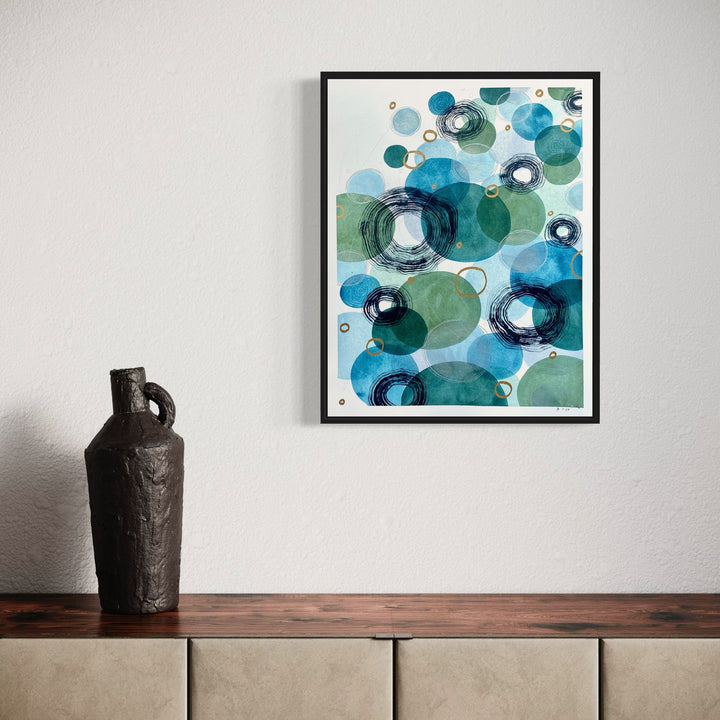 The artwork 'Merciful Depths' by Jocelyn Benford features overlapping circular forms in watercolor, creating a flowing underwater effect. Turquoise, teal, and seafoam green circles blend with deep navy rings, accented by white negative space and delicate ink details. The abstract composition suggests bubbles or marine organisms floating in ethereal waters.