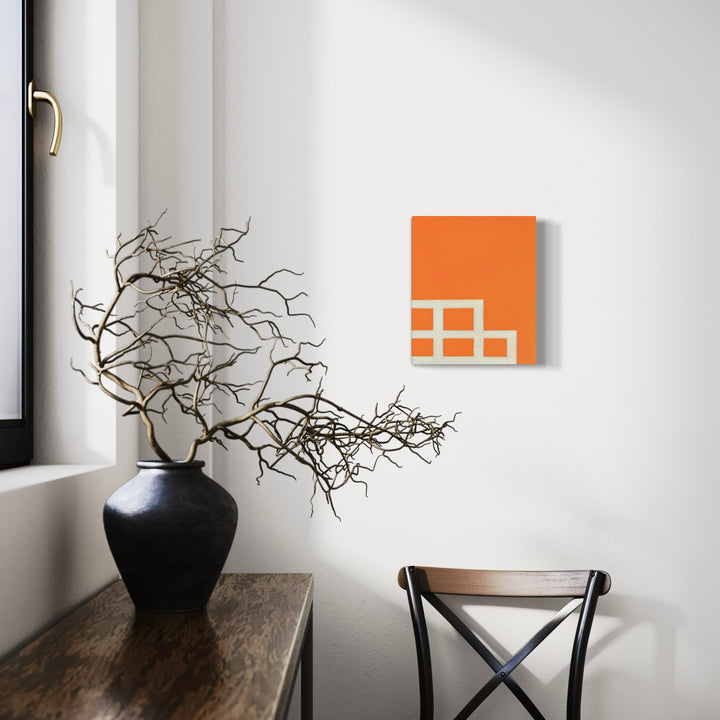 The artwork 'Roots' by Shyun Song features abstract geometric squares in vibrant orange on canvas, displayed in minimalist interior setting