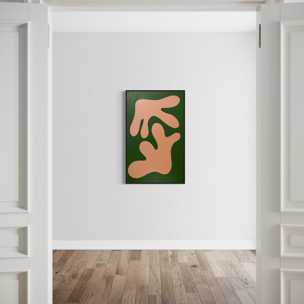 The artwork 'STAGHORN I' by Shadia Sabagh features abstract organic shapes in soft blush pink against a deep forest green background, resembling branching coral or antler forms. The contemporary acrylic painting on canvas creates a striking minimalist composition mounted on a clean white wall. Dimensions: 30x48 inches. By Shadia Sabagh.