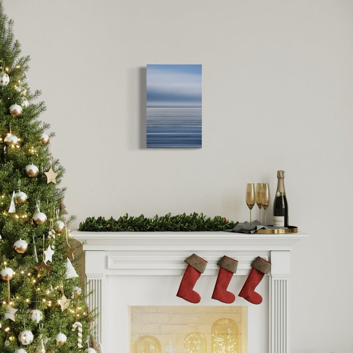 The artwork 'Sun Streaks on Pacific' by Neil Shapiro captures a serene seascape with gentle gradients of blue tones merging from sky to ocean. The minimalist composition features a soft horizon line where misty atmosphere meets calm waters, creating an abstract effect that emphasizes the peaceful nature of the ocean landscape printed on textured Hahnemühle paper.