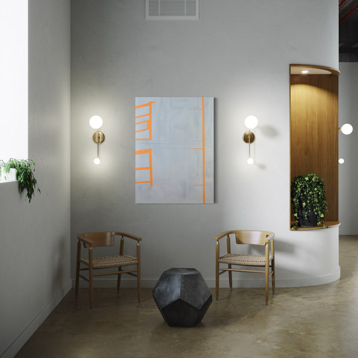 The artwork 'Sunrise in the West 18' by Cora Jane Glasser features geometric orange lines on a light gray background, displayed in a modern interior setting with minimalist wall sconces. The abstract oil painting shows vertical and horizontal strokes creating a structured composition, mounted on wood-braced plexi, measuring 49x36 inches.
