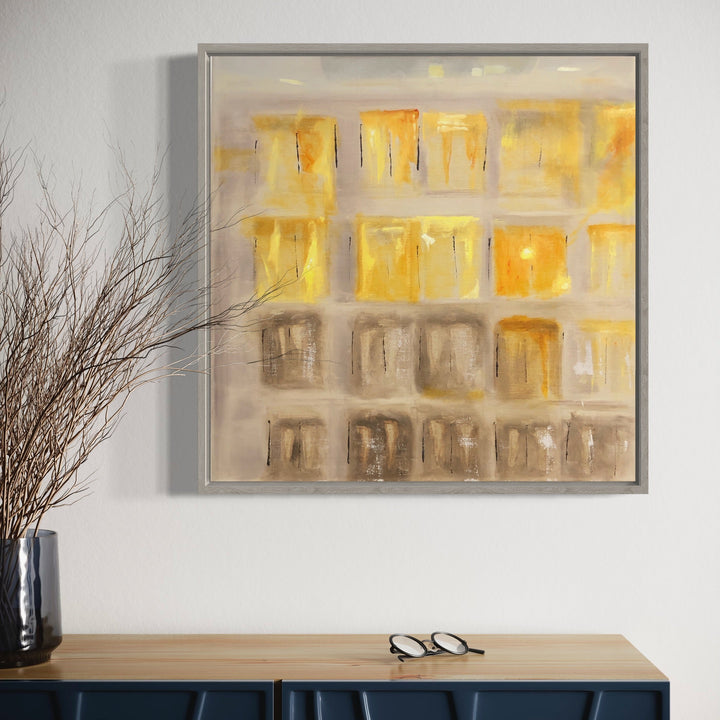 The artwork 'Sunset in the East-1' by Cora Jane Glasser features an abstract grid composition with luminous golden squares fading into muted beige tones. Oil on linen painting showcases a modernist architectural interpretation with warm sunset hues, textural brushstrokes, and geometric patterns within a sleek frame, 20x20 inches.