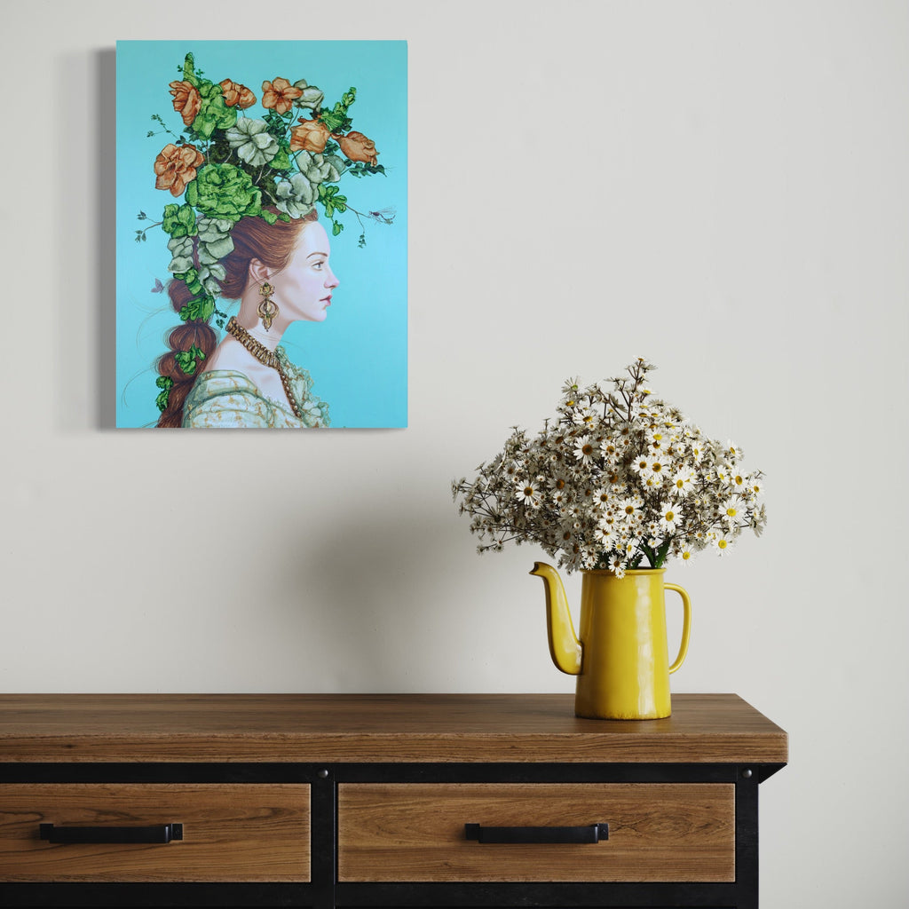 The artwork 'Symbols and Icons II' by Carlos Gamez de Francisco features an elegant portrait against a vibrant turquoise background. A lush floral arrangement adorns the subject's head, combining green foliage with peach-colored blooms. The figure wears ornate jewelry and a light-colored dress, painted in acrylic on wood with Renaissance-inspired styling.
