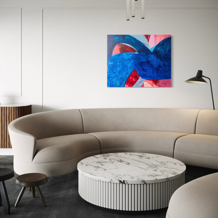 Symphony 12 by Carin Kulb Dangot features bold abstract shapes in vibrant cobalt blue and coral pink on canvas. Dynamic curved forms create a sense of movement and rhythm, with textured brushstrokes adding depth to the acrylic composition. The interplay of cool and warm tones creates a striking contemporary artwork measuring 36 x 44 inches.