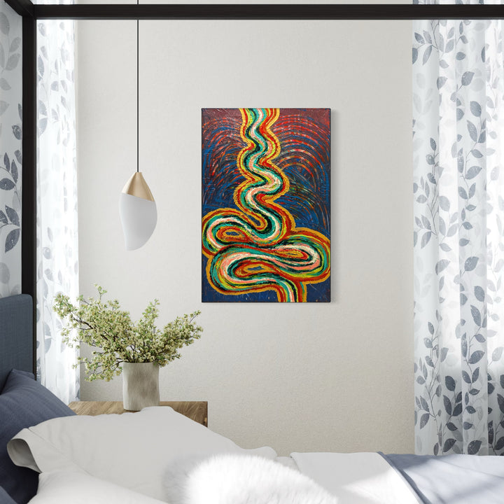 The Journey by Hillary Hany features vibrant, swirling lines in shades of green, orange, and yellow against a rich blue and reddish background, evoking a sense of movement and flow. Positioned above a minimal wooden bedside table with simple decor, it adds a dynamic, contemplative touch to a bright, softly lit bedroom space.
