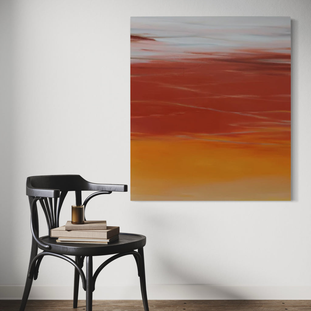 The artwork 'Waves #89' by Bob Melzmuf features a striking abstract seascape in oil on canvas, depicting layers of warm terracotta red transitioning into golden orange hues. The horizontal brushstrokes create a serene atmospheric effect, suggesting a dramatic sunset over calm waters, mounted on a white wall above a black wooden chair.