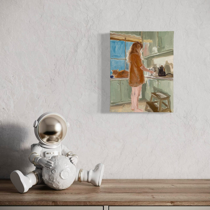 The artwork 'Morning Coffee Study' by Jillian Shea depicts a contemplative kitchen scene. A figure in a rust-colored robe reaches into mint-green cabinets beside a blue window. Oil on canvas captures soft morning light and domestic tranquility through loose brushstrokes and muted pastel palette, 14x11 inches by Jillian Shea.